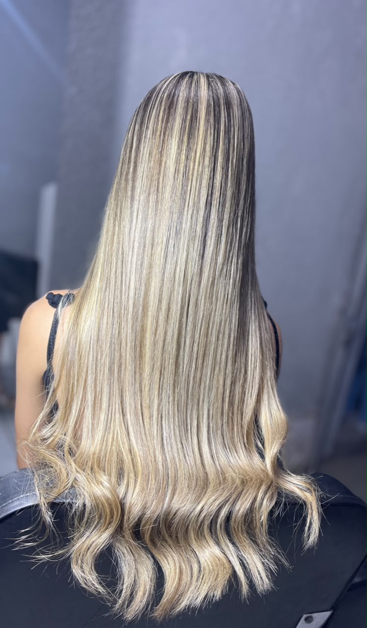 Cabelo loiro longo com mechas iluminadas, visto de costas